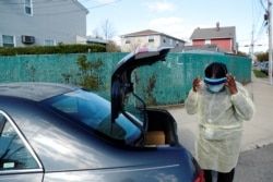 Home care nurse Flora Ajayi dons personal protective equipment (PPE) to protect herself and prevent cross-contamination while visiting a client during the ongoing coronavirus disease (COVID-19) outbreak, in the Queens borough of New York City.