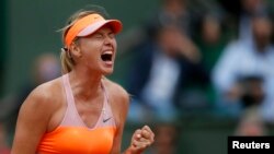Maria Sharapova dari Rusia bereaksi setelah mengalahkan Garbine Muguruza dari Spanyol dalam perempat final Perancis Terbuka di stadion Roland Garros di Paris (3/6). (Reuters/Gonzalo Fuentes)