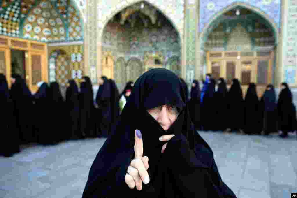 An Iranian woman displays her ink-stained finger after voting in the parliamentary and Experts Assembly elections at a polling station in Qom. Polls opened Friday in parliamentary elections, the country's first since its landmark nuclear deal with world powers last summer.