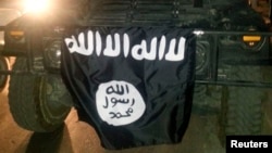 FILE - The flag of the Islamic State is displayed in Mosul, Iraq.