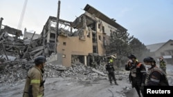 Rescuers stand at a site of a Russian missile strike in Kryvyi Rih, Ukraine, on Aug. 27, 2024.