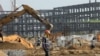 A worker walks past excavators at a construction site of the Dangote refinery in Ibeju Lekki district, on the outskirts of Lagos, Nigeria, August 7, 2019. 