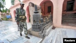 An Indian security personnel walks next to bloody footprints inside the Mahabodhi temple complex, after a series of explosions at Bodh Gaya in the eastern Indian state of Bihar, July 7, 2013.