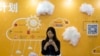 A woman uses her smartphone near a booth promoting cloud services during the Global Mobile Internet Conference in Beijing, China, April 29, 2016.