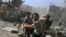 FILE - Men transport a casualty after what activists said were airstrikes by forces loyal to Syria's President Bashar al-Assad on a busy marketplace in Douma, near Damascus, Syria, Aug. 12, 2015. 