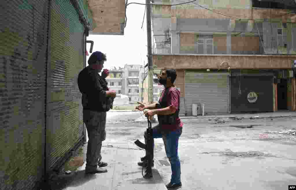 Rebel fighters of the Syrian Kurdish Popular Protection Units (YPG) talk in the Sheikh Maqsoud neighborhood of Aleppo, May 9, 2013. 