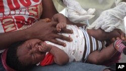 FILE - The Ebola outbreak has masked cases of malaria and other contagious diseases. A child gets vaccinated at a health center near Monrovia, Liberia.