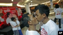 Men kiss among other couples participating in the Guinness World Record attempt in the longest continuous kiss in Pattaya, Thailand, February 12, 2012.
