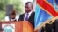 FILE - Incumbent Congo President Joseph Kabila holds the Congolese flag as he takes the oath of office as he is sworn in for another term, in Kinshasa, Democratic Republic of Congo.