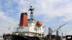 FILE - In this March 4, 2016 file photo, crewmen of the North Korean cargo vessel Jin Teng stand on the middle of the deck as it unloads its cargo while docked at Subic Bay, in Zambales province, northwest of Manila, Philippines. 