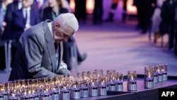 মৃত্যু শিবির থেকে বেঁচে যাওয়া একজন আউশভিটজ মুক্ত হওয়ার ৮০তম বার্ষিকী অনুষ্ঠানে মোমবাতি প্রজ্বলন করছেন। ফটোঃ ২৭ জানুয়ারি, ২০২৫। 