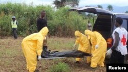 Health workers carry the body of an Ebola virus victim in the Waterloo district of Freetown, Liberia, Oct. 21, 2014. 