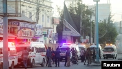Des agents de sécurité somaliens sur le site de l'explosion d'une voiture piégée alors que les ambulanciers attendent pour secourir les blessés à Mogadiscio, en Somalie, le 31 janvier 2021. REUTERS/Feisal Omar
