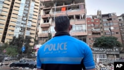 A Lebanese police officer looks at damaged apartments that were hit by Israeli strike early Sept. 30, 2024. 