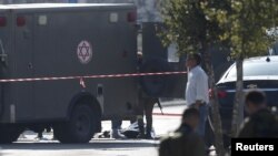 The body of a Palestinian, who Israeli police said stabbed and wounded two security guards, is seen on the ground near a military ambulance, near the West Bank Jewish settlement of Ariel, Dec. 24, 2015. 