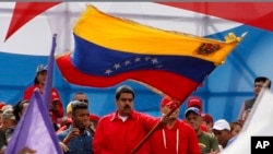 Venezuela's President Nicolas Maduro waves the Venezeulan flag during a rally in Caracas, Venezuela, July 27, 2017. Maduro has provoked international outcry and enraged an opposition demanding his resignation with his push to elect an assembly that will rewrite the constitution. 