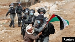 A Palestinian demonstrator scuffles with an Israeli border police member during a protest against Jewish settlements and U.S. President Donald Trump, in Beit Dajan in the Israeli-occupied West Bank, Nov. 6, 2020. 