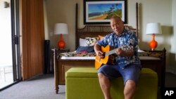 Charles Nahale plays the only guitar he took with him from the wildfire on Oct. 10, 2023, in Lahaina, Hawaii. Nahale had many guitar and ukulele collections that were burned down in his home on Front Street. 