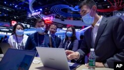 People view laptop computers from Chinese tech firm Huawei at the PT Expo in Beijing, Wednesday, Sept. 14, 2020. (AP Photo/Mark Schiefelbein)
