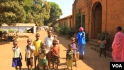 Young IDPs play in front of church buildings at the St. Mary Help of Christians Cathedral in Wau, Western Bahr el Ghazal, Dec. 8, 2016. (J. Craig/VOA) 