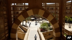 FILE - Students walk in the campus of the American University in Cairo, in New Cairo. In the summer of 2020, more than a hundred allegations of sexual harassment, assault, rape against a former AUC student have roiled Egypt.