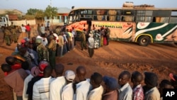 FILE - Passengers hoping to travel to Nairobi line up at a bus in the town of Mandera near the Kenya-Somalia border, Dec. 8, 2014.