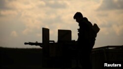 A member of Syrian Democratic Forces (SDF) stands on a pick up truck mounted with a weapon near Baghouz, Deir Al Zor province, Syria February 11, 2019.