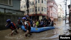 Security force members use an inflatable raft to bring residents to safety from a flooded area near the bank of the overflowing Bagmati River following heavy rains in Kathmandu, Nepal, on Sept. 28, 2024. 