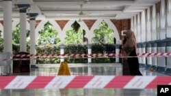 A woman wearing a protective mask walks at a mosque following the outbreak of coronavirus, in Kuala Lumpur, Malaysia March 16, 2020. REUTERS/Lim Huey Teng