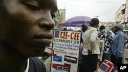 Andrew Owoyemi buys a telephone hand-set at the computer village in Lagos, Nigeria, March 2006.