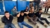 Suspects in the assassination of Haiti's President Jovenel Moise sit on the floor handcuffed after being detained, at the General Direction of the police in Port-au-Prince, Haiti, July 8, 2021. 