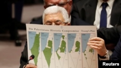 Palestinian President Mahmoud Abbas holds a document while speaking during a Security Council meeting at the United Nations in New York, Feb. 11, 2020. 