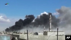 Smoke rises after airstrikes by military jets in Talbiseh, a city in western Syria’s Homs province, where Russia launched airstrikes for the first time, Sept. 30, 2015. The image was made from video provided by Homs Media Center and authenticated by AP. 