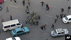 Military police and soldiers walk among traffic as they clear remaining protesters in Tahir square in Cairo, Egypt. Egypt's military rulers dissolved parliament Sunday, suspending the constitution and promising elections in moves cautiously welcomed by pr