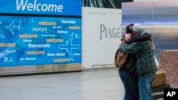 Abdullah Alghazali, right, hugs his 13-year-old son Ali Abdullah Alghazali after the Yemeni boy stepped out of an arrival entrance at John F. Kennedy International Airport in New York, Feb. 5, 2017.