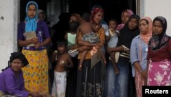 Rohingya migrant women, who recently arrived in Indonesia by boat, are seen inside a temporary compound for refugees in Aceh Timur regency, Indonesia's Aceh Province, May 21, 2015. 
