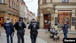 Anggota pasukan penertiban dan petugas polisi tampak melakukan inspeksi untuk memeriksa penerapan protokol kesehatan terkait COVID-19 di Pirna, Jerman, pada 24 November 2021. (Foto: Reuters/Matthias Rietschel)