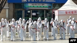 Tentara Korea Selatan dengan baju hazmat menyemprotkan cairan disinfektan sebagai upaya mencegah penyebaran virus korona COVID-19, di Balai Kota Daegu, 2 Maret 2020. (Foto: AFP)