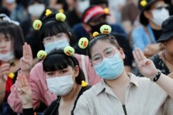 Protesters flash the three-finger protest gesture during a rally in Bangkok, Thailand, Nov. 25, 2020.