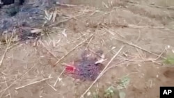 This image taken from video Dec. 7, 2021, shows bloodstains on the ground near several charred corpses in the town of Done Taw, in Myanmar's Sagaing region.