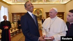 Paus Fransiskus (kanan) memberi Presiden Obama sebuah dokumen kepausan berjudul 'The Joy of Gospel' di Vatikan, Kamis (27/3). 