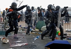 A policeman fires with a pepper ball gun towards protesters near the Legislative Council in Hong Kong, June 12, 2019.