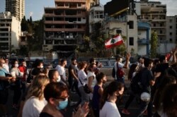 People march in honor of the victims of the last week's explosion that killed over 150 people and devastated the city, near the blast site in Beirut, Lebanon, Aug. 11, 2020.