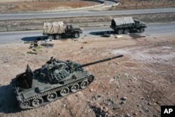 Abandoned Syrian army armored vehicles sit on a road as opposition insurgents control the outskirts of Hama, Syria, Dec. 3, 2024.