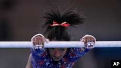 Simone Biles, of United States performs on the uneven bars during the women's artistic gymnastic qualifications at the 2020 Summer Olympics, July 25, 2021, in Tokyo. 