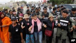 Cambodian civil rights supporters are forcibly directed by riot police as they march in protest of charges brought against local rights activists near Prey Sar prison, outside Phnom Penh, Cambodia, May 9, 2016. 