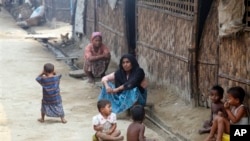 FILE - Myanmar Muslims, who identify themselves as long-persecuted “Rohingya” Muslims, sit on the ground at Da Paing camp for Muslim refugees in north of Sittwe, Rakhine State.