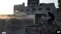 In this citizen journalism image provided by Aleppo Media Center AMC, a Syrian rebel fires a weapon towards Syrian government troops loyal to President Bashar Assad in Aleppo, Nov. 9, 2013.