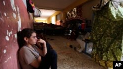 FILE - An internally displaced Yazidi who fled from an Iraqi town after advances by Islamic militants takes shelter at a school in Dahuk, 260 miles (420 kilometers) northwest of Baghdad.
