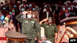 Chairman of Sudan's Sovereignty Council General Abdel Fattah al-Burhan performs a military salute during a reception ceremony upon the arrival of the government negotiating team from Juba, in the capital Khartoum, Oct. 8, 2020.
